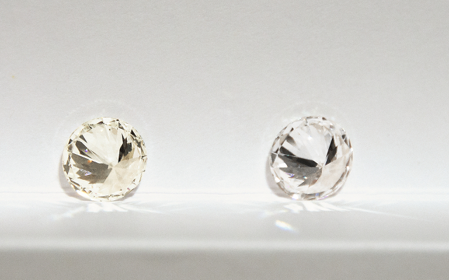 Two diamonds of different color grades compared side by side on a plain background.