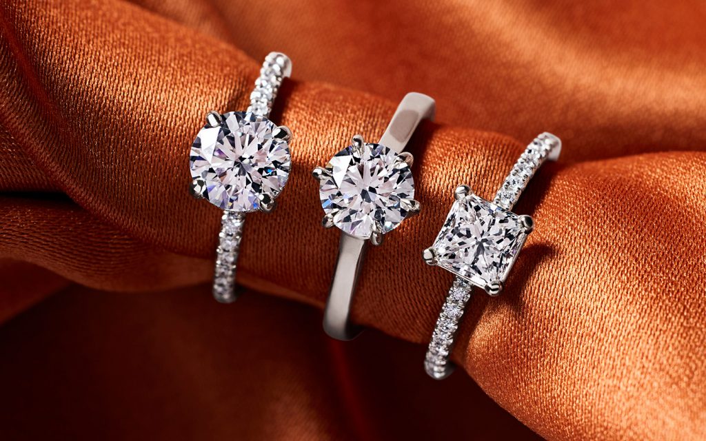 Three diamond engagement rings in white gold and platinum.