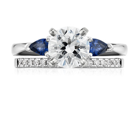 Sapphire and diamond engagement ring on top of a diamond band. 