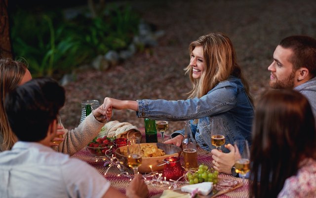 Woman showing her engagement ring to a friend at a table 