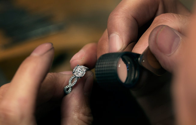 Close up of a jeweler inspecting a diamond engagement ring