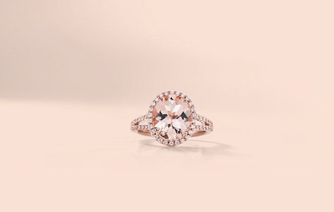 A morganite engagement ring on a pink background