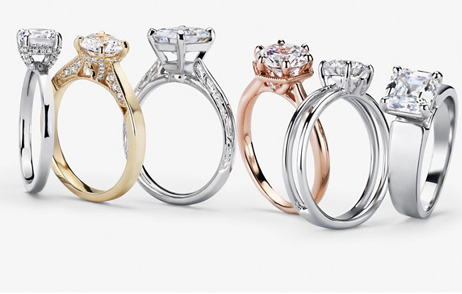 Six diamond engagement rings made of different metals