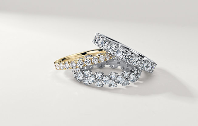 Three diamond women's wedding rings stacked on a white background