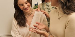 Three women are admiring a gifted diamond necklace