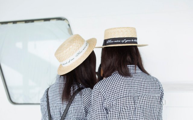 Couple facing away from the camera showing their matching straw hats 