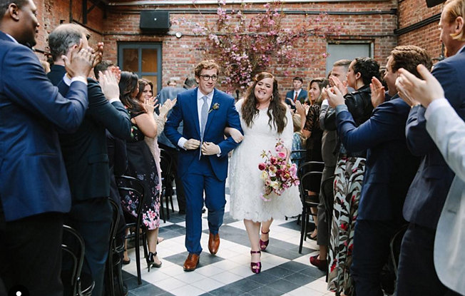 Aidy Bryant and Connor O'Malley walking down the aisle during their wedding