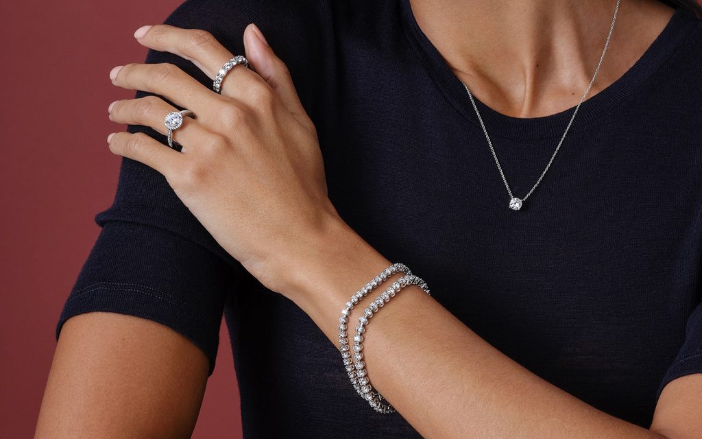 Photo of a woman's arm with diamond jewelry.