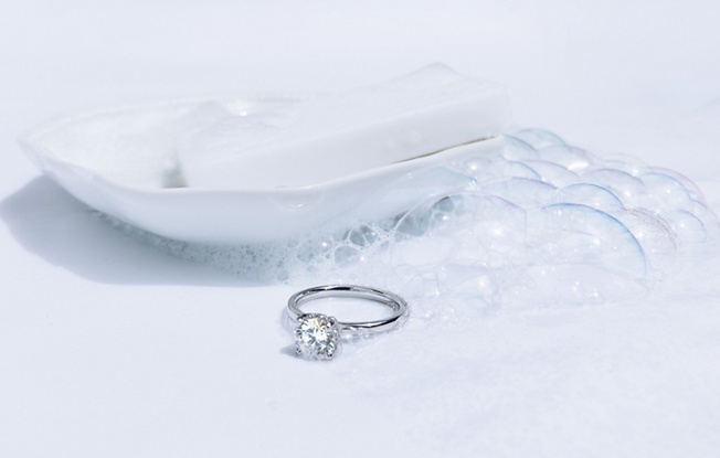 Engagement ring in front of soap on a dish 