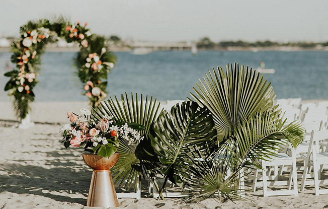 A boho beach wedding setup on the sand at Catamaran Resort Hotel and Spa