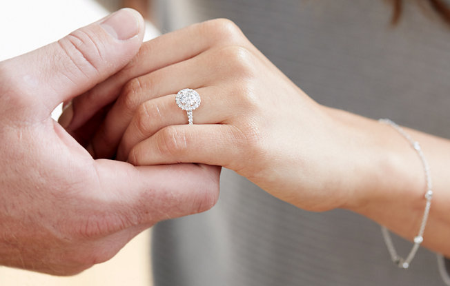 Close up of woman's hand, she is wearing an engagement ring 