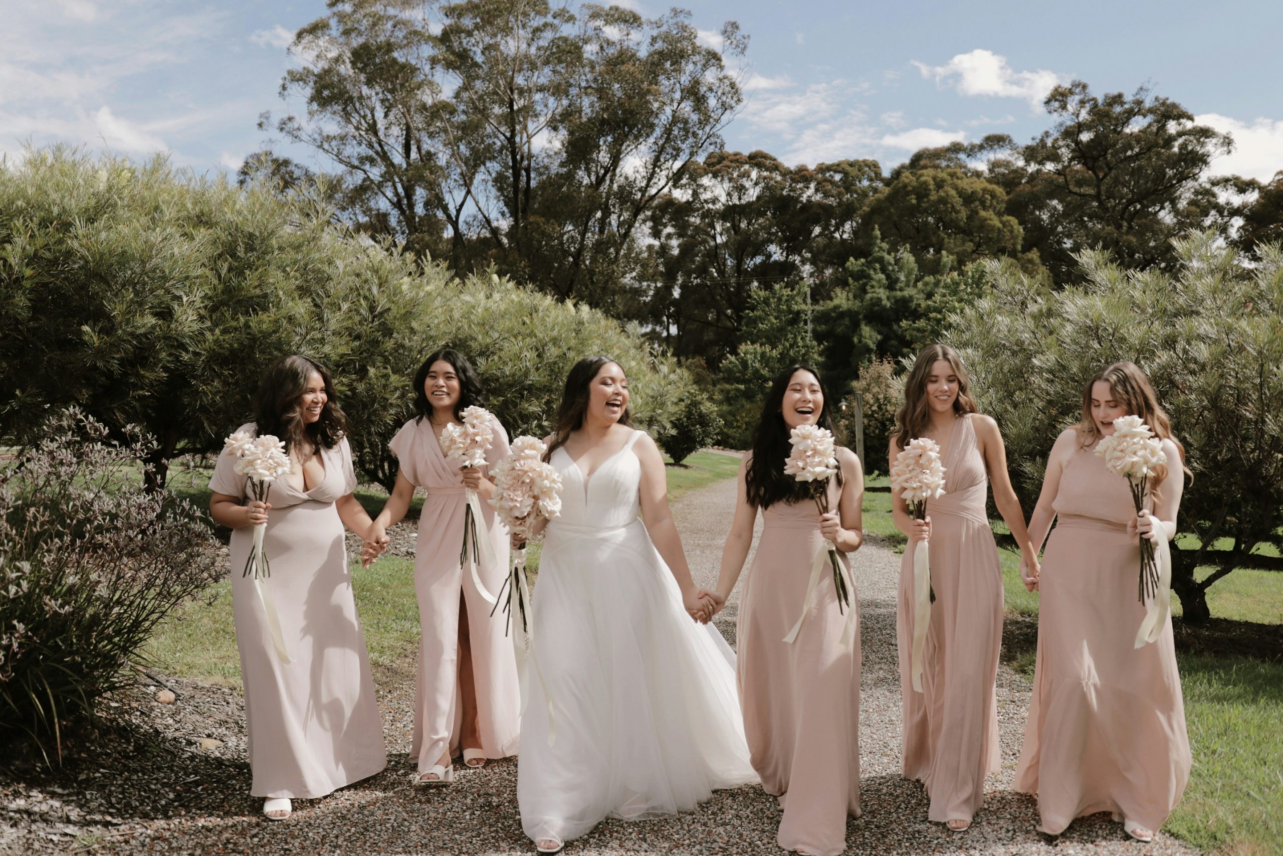 Bride smiling with her five bridesmaids on her wedding day. 