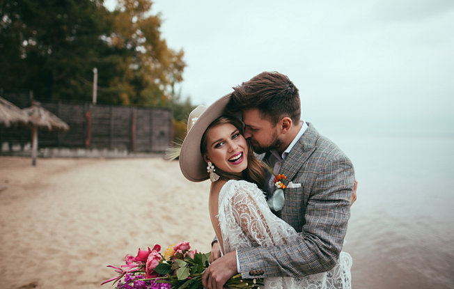 Newlyweds embrace on a tropical beach