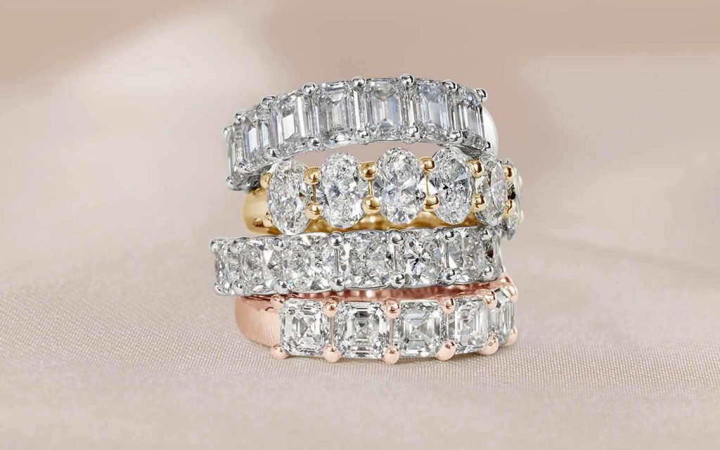 Stack of four wedding rings in rose, yellow, and white gold with brilliant and step-cut diamonds. 