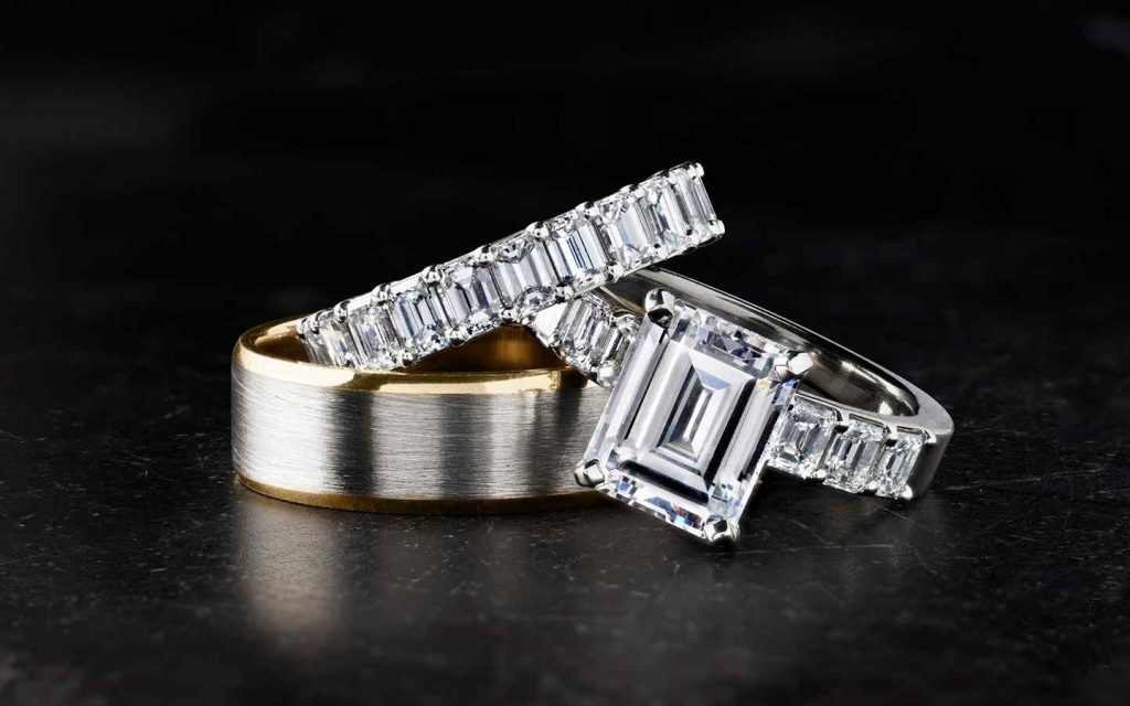 Three rings including two emerald cut diamond rings.