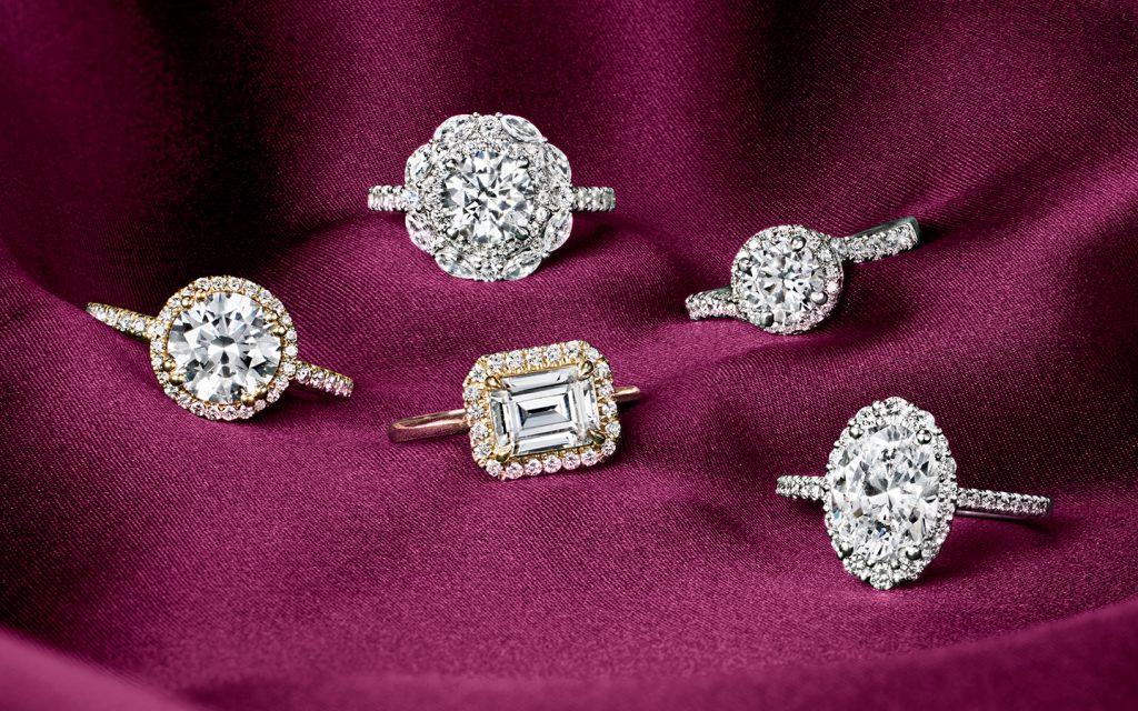 Five diamond and gold engagement rings with round, emerald and oval diamonds. 