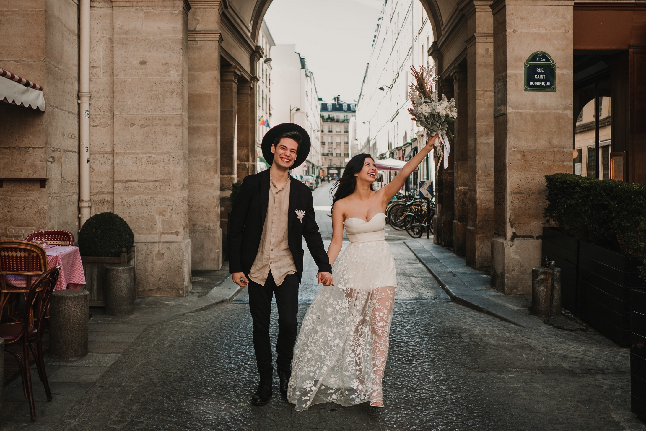 Bride and groom smiling as they walk together through the streets of Paris following their elopement.