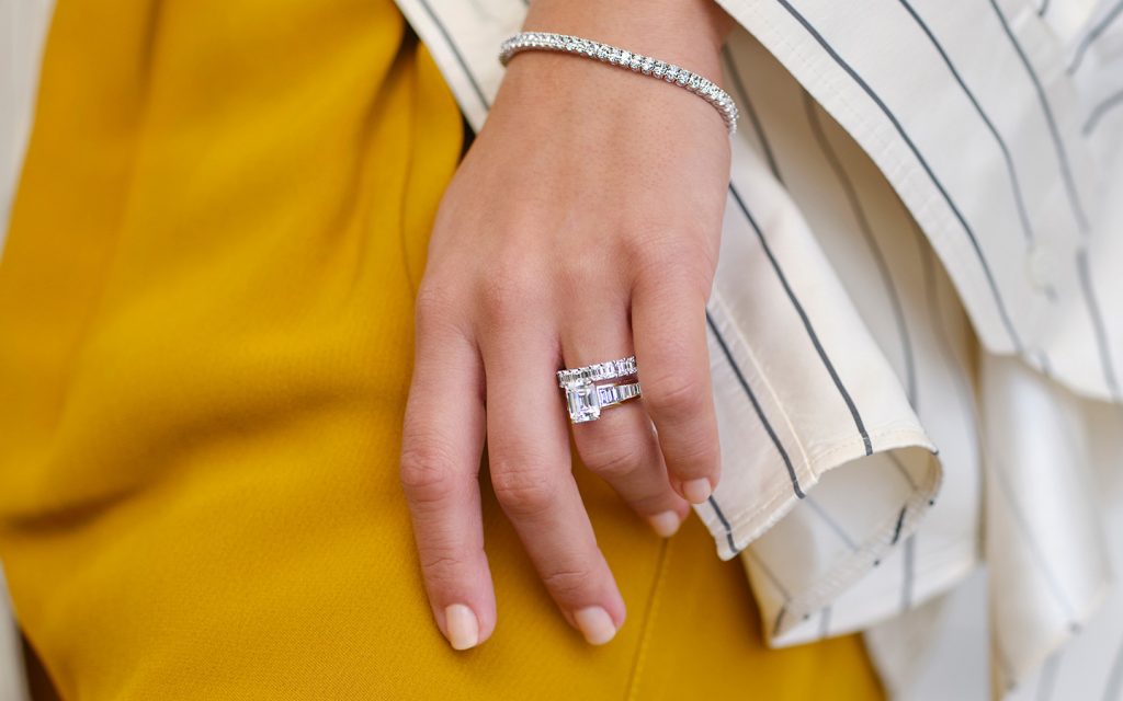 Photo of a woman's hand, showcasing her engagement ring.