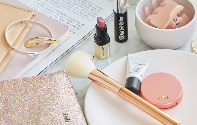 Various beauty products from IPSY laid out on a white table