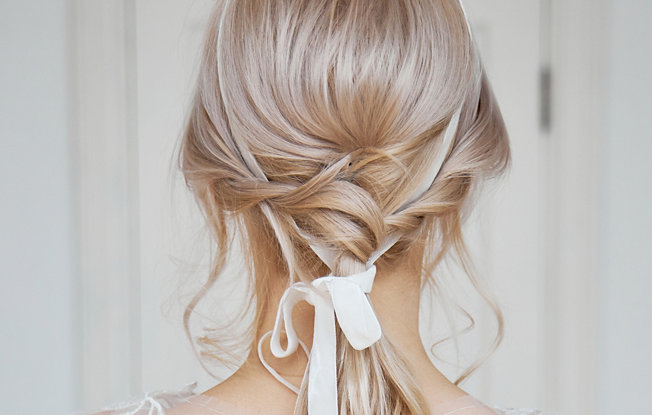 A woman with straight blonde hair pulled back into a low bun for her wedding