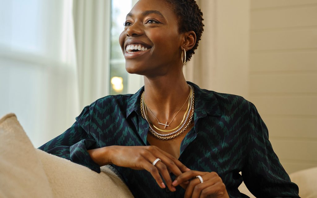 Smiling woman wearing mixed metal Blue Nile jewelry. 