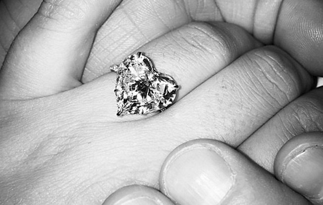 Lady Gaga shows off her heart shaped diamond engagement ring while holding hands with her partner