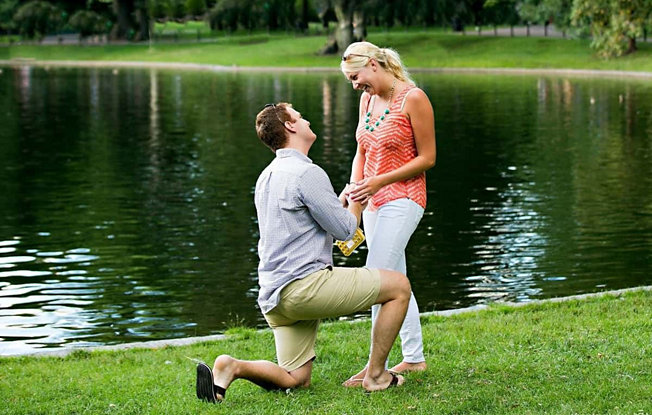 Couple getting engaged in park near pond