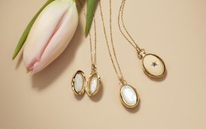 Mother of pearl lockets next to a gold locket. 