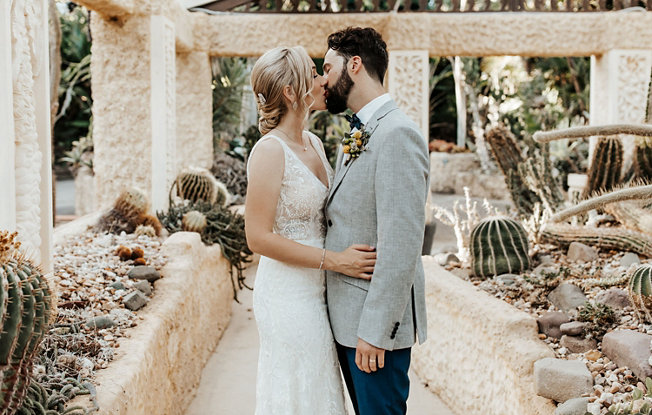 A bride and groom kiss amongst a midwestern themed garden
