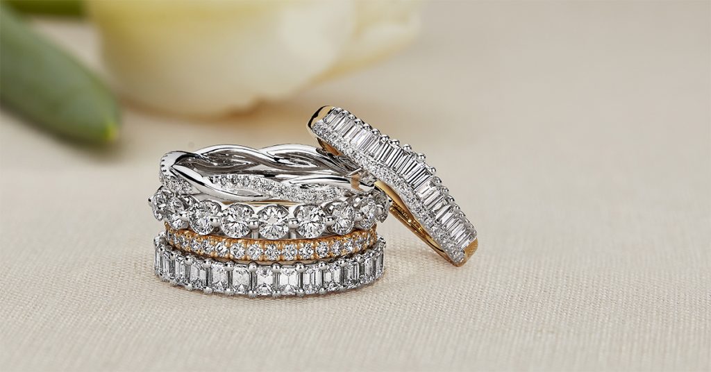 Stack of diamond and gold bands, including promise rings. 