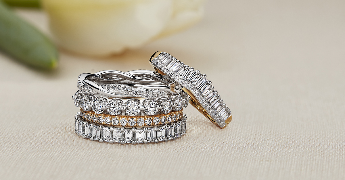 Stack of diamond and gold bands, including promise rings. 