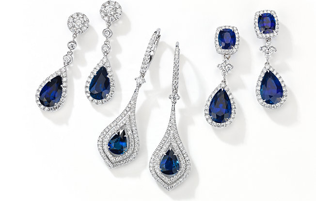 Three pairs of tear drop sapphire earrings from Blue Nile on a white background