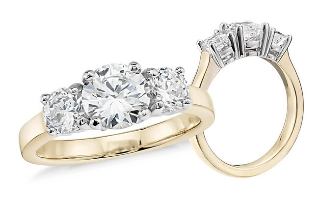 A yellow gold and diamond trilogy engagement ring shown from the top and the side