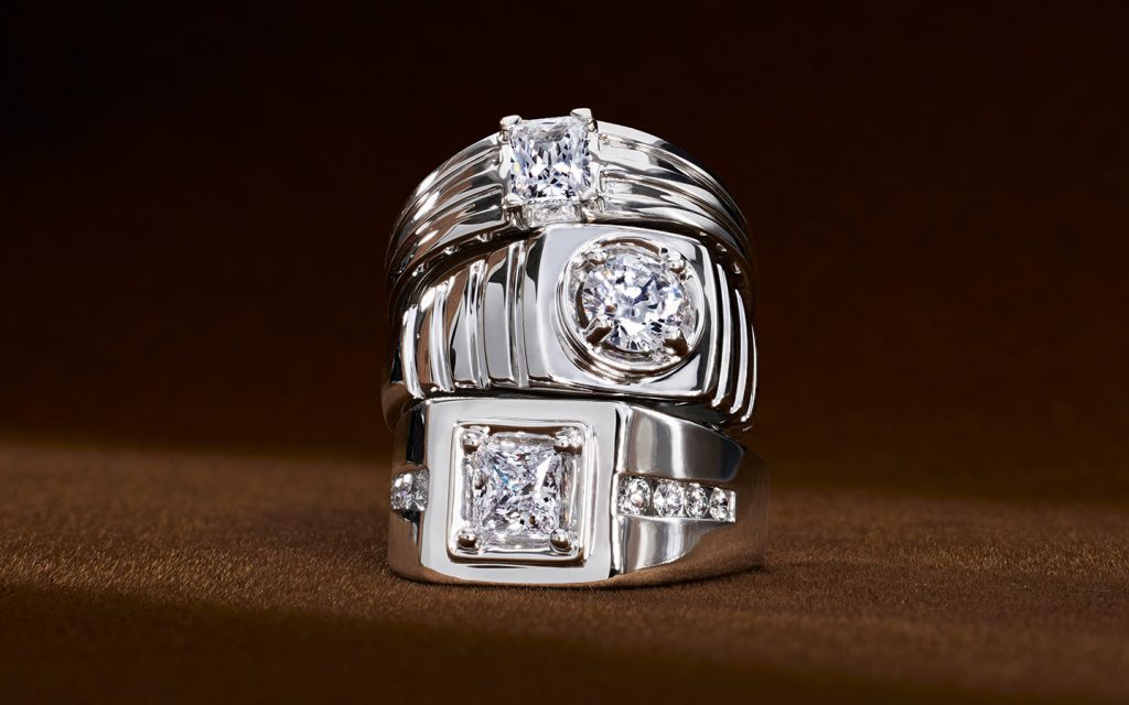 Stack of three men’s engagement rings with diamonds and white gold.