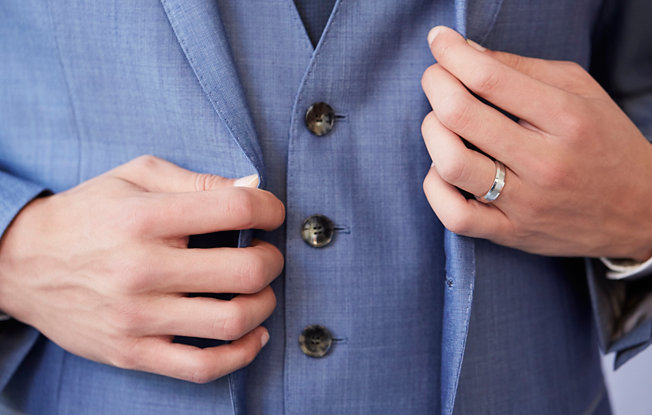 Groom's hands as he adjusts his blazer 