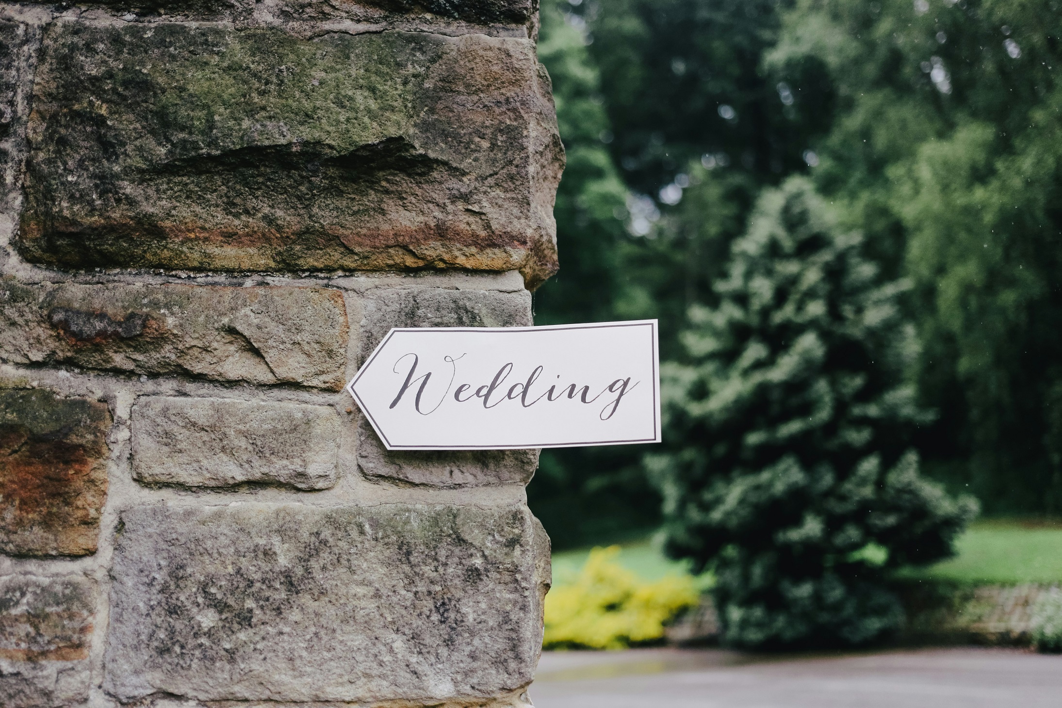Paper sign pointing to a wedding reception. 