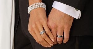 Photo of a bride and groom’s hands on their wedding day, they are each wearing their wedding rings. 