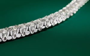 Close up of the gold prongs on a white gold tennis bracelet. 