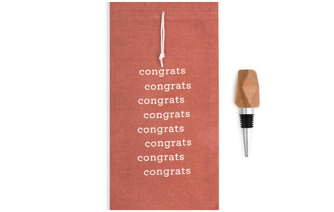A red congratulations card alongside a wooden wine stopper from Demdaco