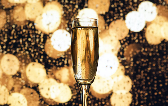 A champagne flute on a gold background