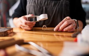 Jeweler looking at a ring under a magnifying glass in preparation to resize it