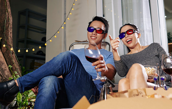 A couple watching a 3D movie in a backyard
