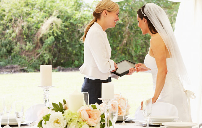 A bride and wedding planner look over a list