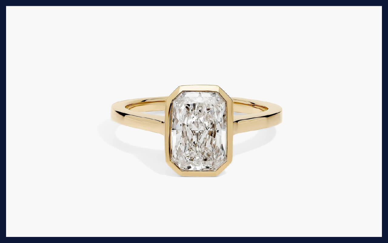 An 18K gold bezel ring featuring a 2ct lab-grown radiant diamond.