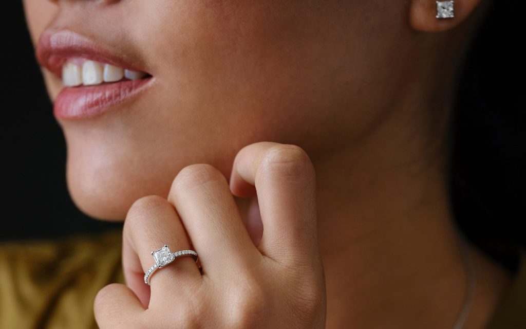 Close up of woman's natural princess-cut diamond engagement ring