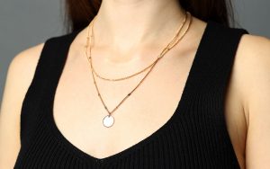 A woman wearing layered necklaces.
