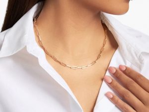 Close up photo on a person wearing a gold necklace