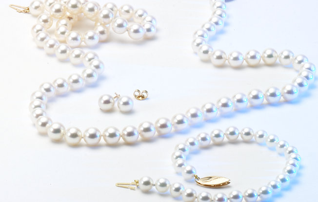 A pearl necklace and bracelet on a white background