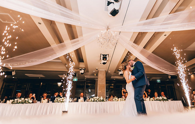 A couple kisses on the dancefloor at a wedding reception