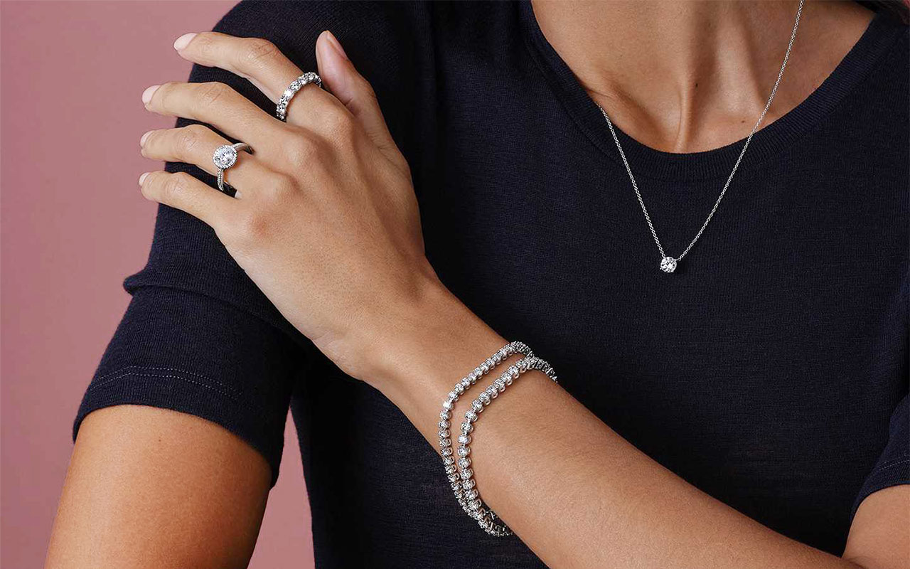 Close-up of a person wearing a mix of platinum and white gold jewelry.